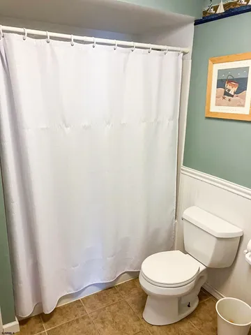 a white toilet sitting next to a shower