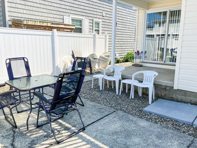 a view of a dinning table and chairs in backyard of the house
