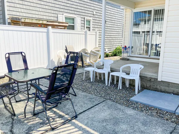 a view of a dinning table and chairs in backyard of the house