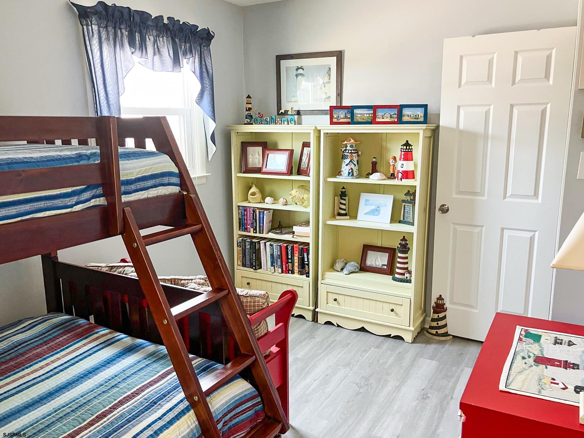 335 42nd Street South, Unit FIRST Brigantine, NJ 08203 - Photo 5 of 23 a bedroom with furniture and a book shelf