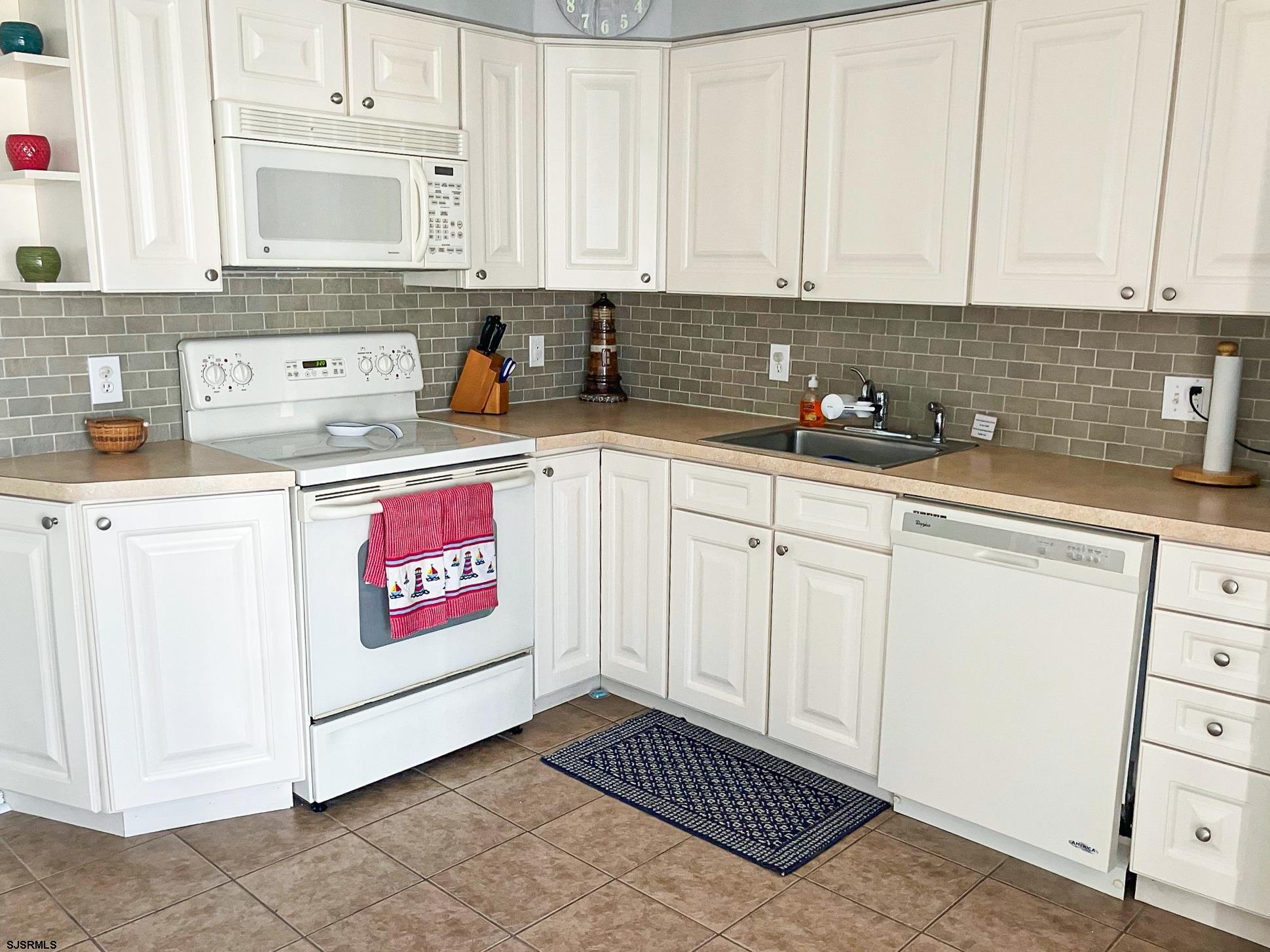 335 42nd Street South, Unit FIRST Brigantine, NJ 08203 - Photo 6 of 23 a kitchen with stainless steel appliances granite countertop a sink and cabinets