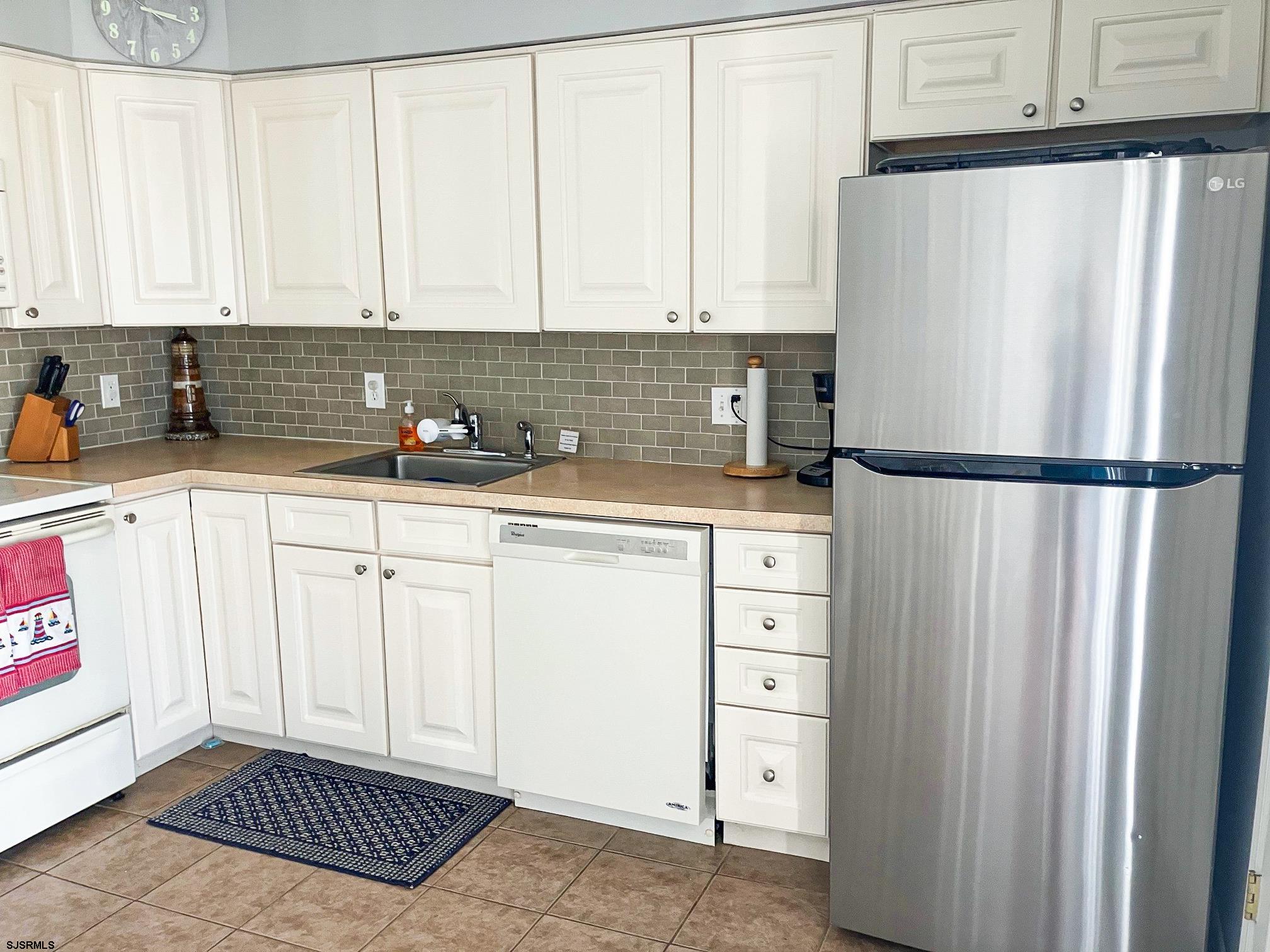 335 42nd Street South, Unit FIRST Brigantine, NJ 08203 - Photo 7 of 23 a kitchen with white cabinets and refrigerator