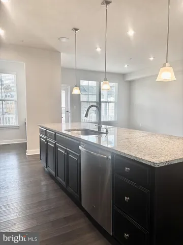 a kitchen with stainless steel appliances granite countertop a sink a oven and a wooden floors