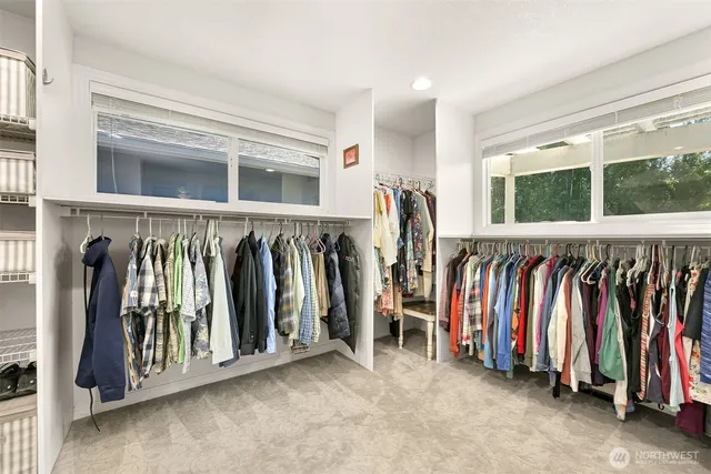 a view of walk in closet with clothes and shoes