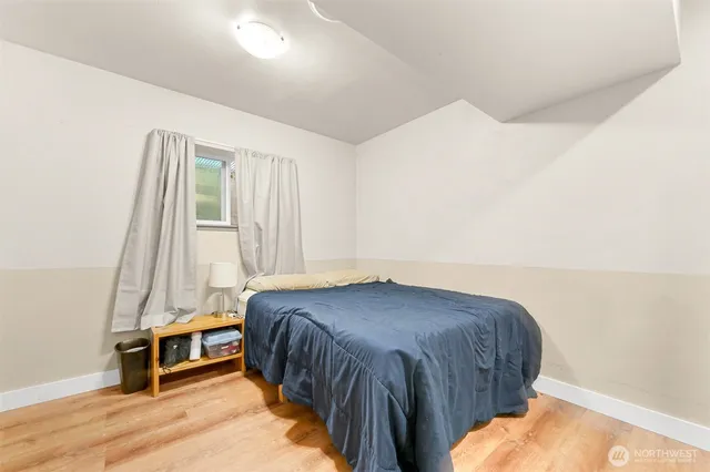 a bedroom with a bed and wooden floor