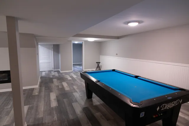 a room with pool table and windows