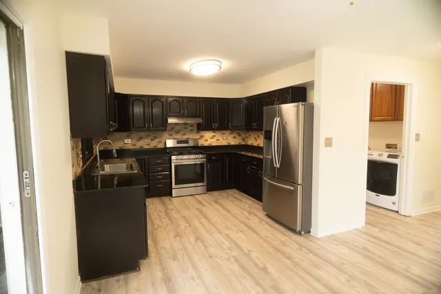 a kitchen with stainless steel appliances granite countertop a stove a refrigerator and a sink