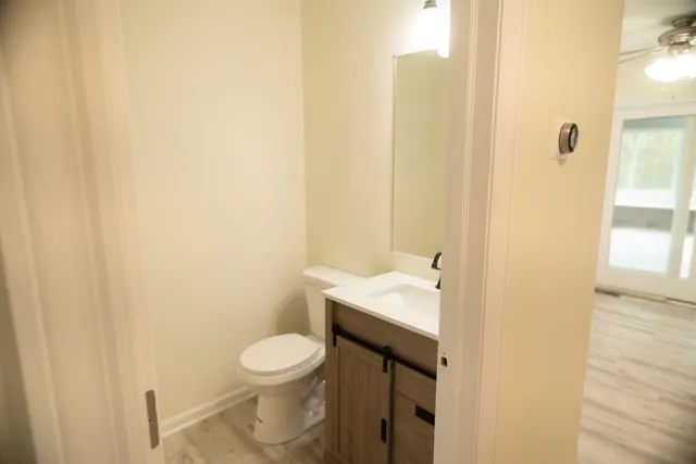 a bathroom with a granite countertop sink a toilet and a mirror