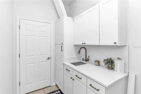 a kitchen with white cabinets and sink