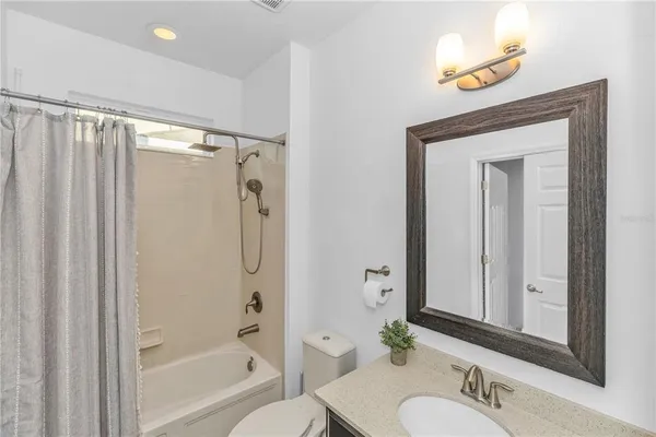 a bathroom with a shower a sink and a mirror