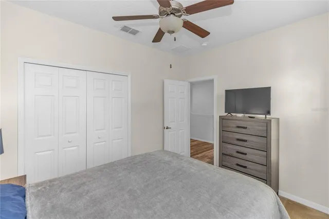 a room with a dresser and a ceiling fan
