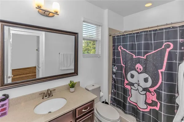 a bathroom with a sink mirror vanity and toilet