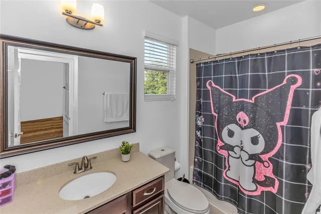 a bathroom with a sink mirror vanity and toilet