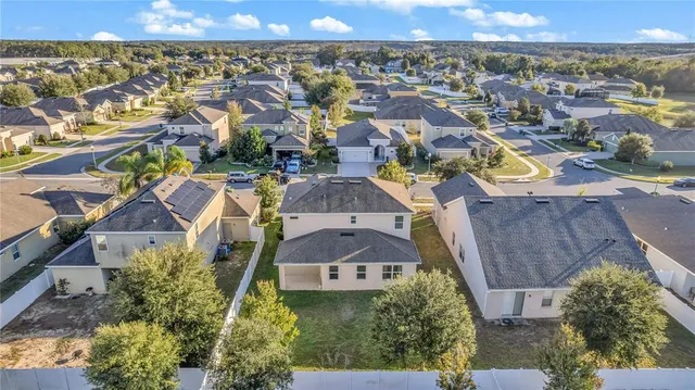 an aerial view of residential houses with outdoor space and swimming pool