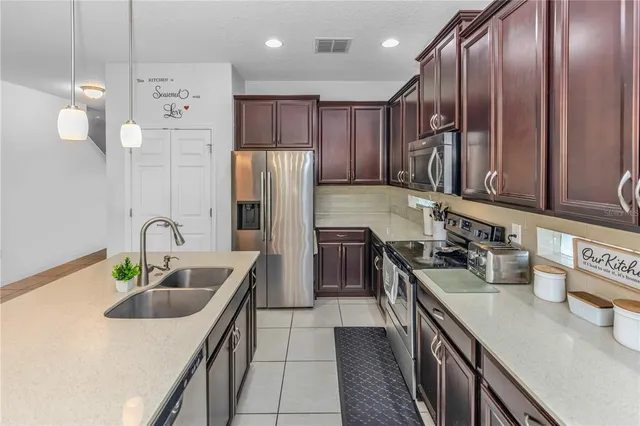 a kitchen with stainless steel appliances granite countertop a sink a stove and a refrigerator