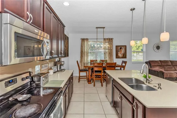 a kitchen with furniture a stove a sink a chimney and a dining table