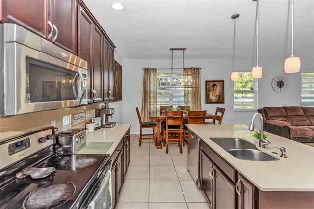 a kitchen with furniture a stove a sink a chimney and a dining table