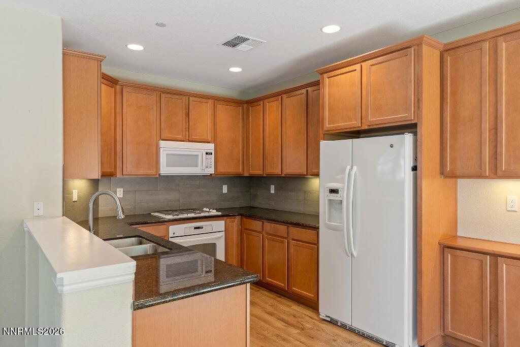 1864 Wind Ranch Road, Unit B Reno, NV 89521 - Photo 15 of 42 a kitchen with a refrigerator sink and cabinets