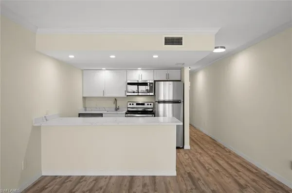 a kitchen with stainless steel appliances granite countertop a refrigerator a stove a sink and a microwave