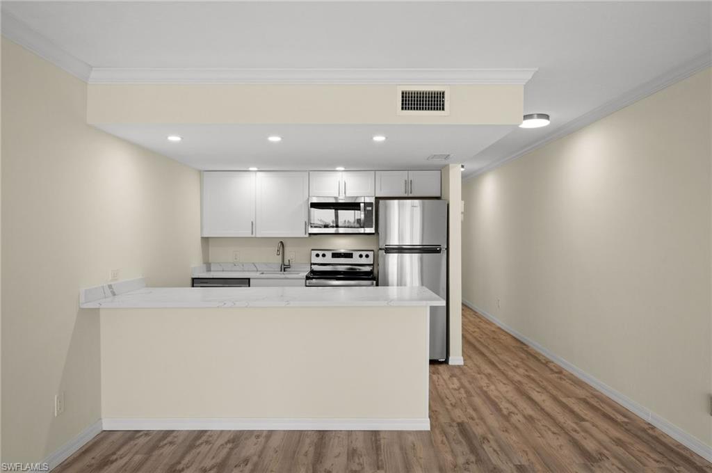 a kitchen with stainless steel appliances granite countertop a refrigerator a stove a sink and a microwave