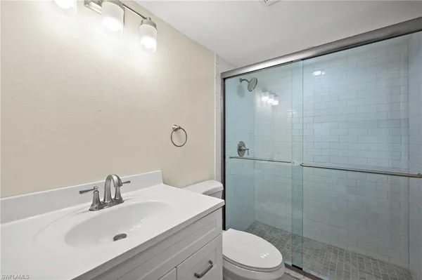 a bathroom with a sink mirror shower and toilet