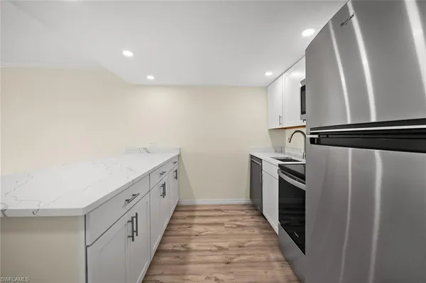 a kitchen with white cabinets and stainless steel appliances