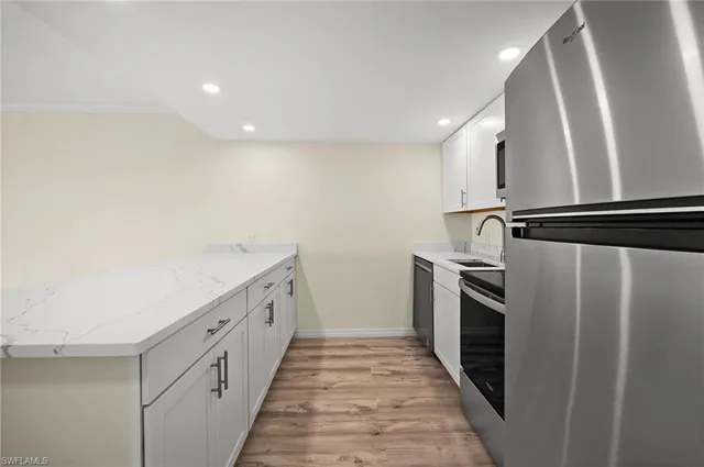 a kitchen with white cabinets and stainless steel appliances