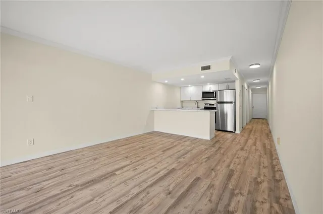 a view of a kitchen with a sink and wooden floor