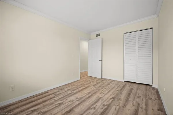 a view of empty room with wooden floor