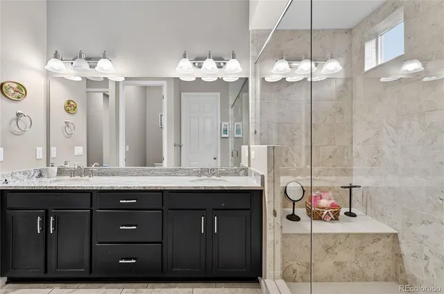 a bathroom with a granite countertop sink a large mirror and a shower