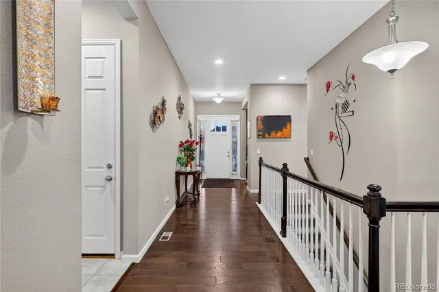 a view of a hallway with wooden floor and windows
