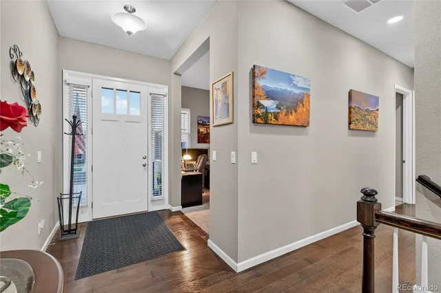 a view of a hallway with workspace and wooden floor