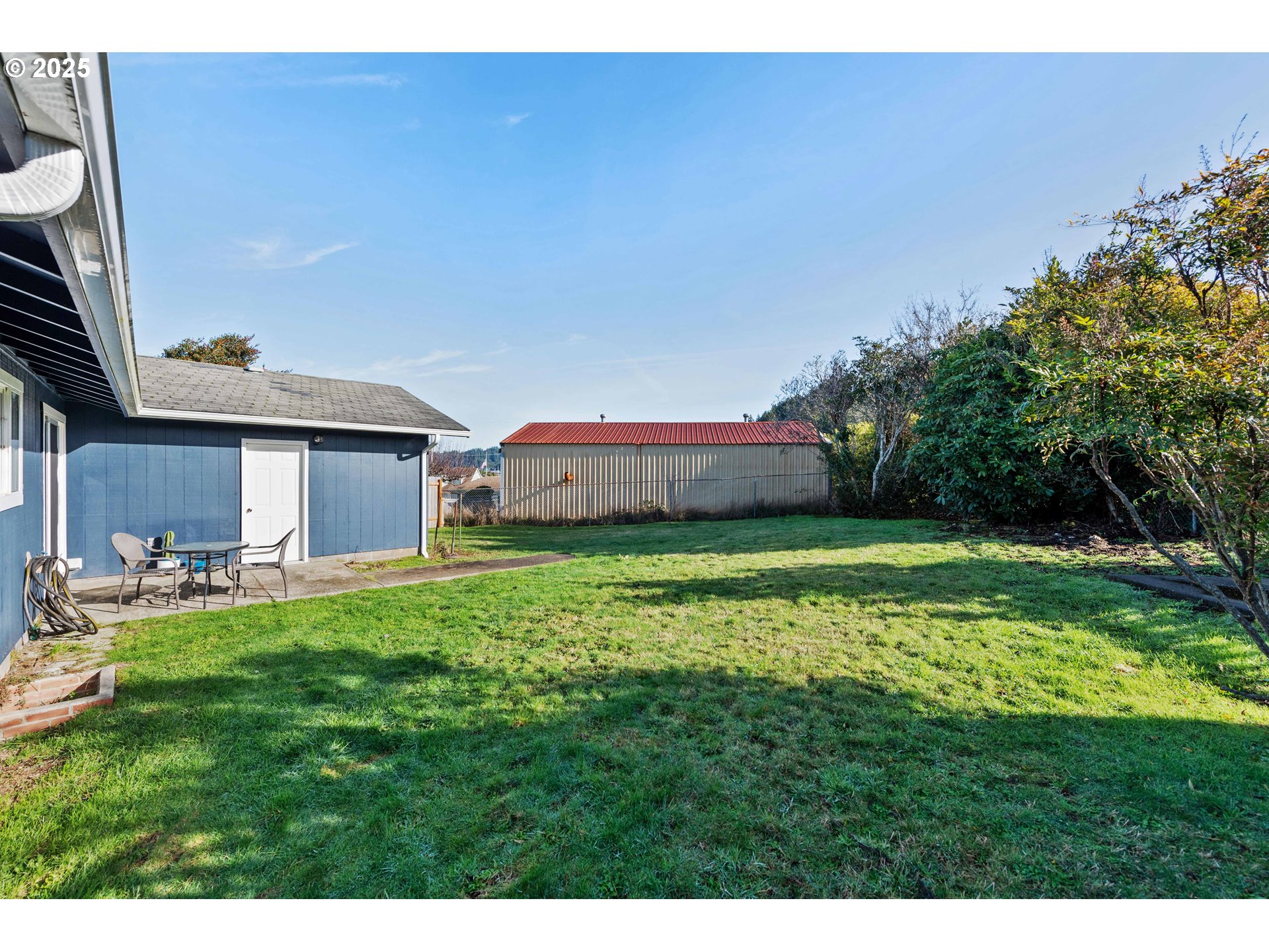124 Holly Court Reedsport, OR 97467 - Photo 29 of 30 a backyard of a house with large trees and plants