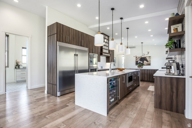 140 West Vista Road Kamas, UT 84036 - Photo 11 of 101 Gourmet kitchen featuring a large central island with integrated wine cooler, stainless steel appliances, wood-finish cabinetry, and recessed lighting