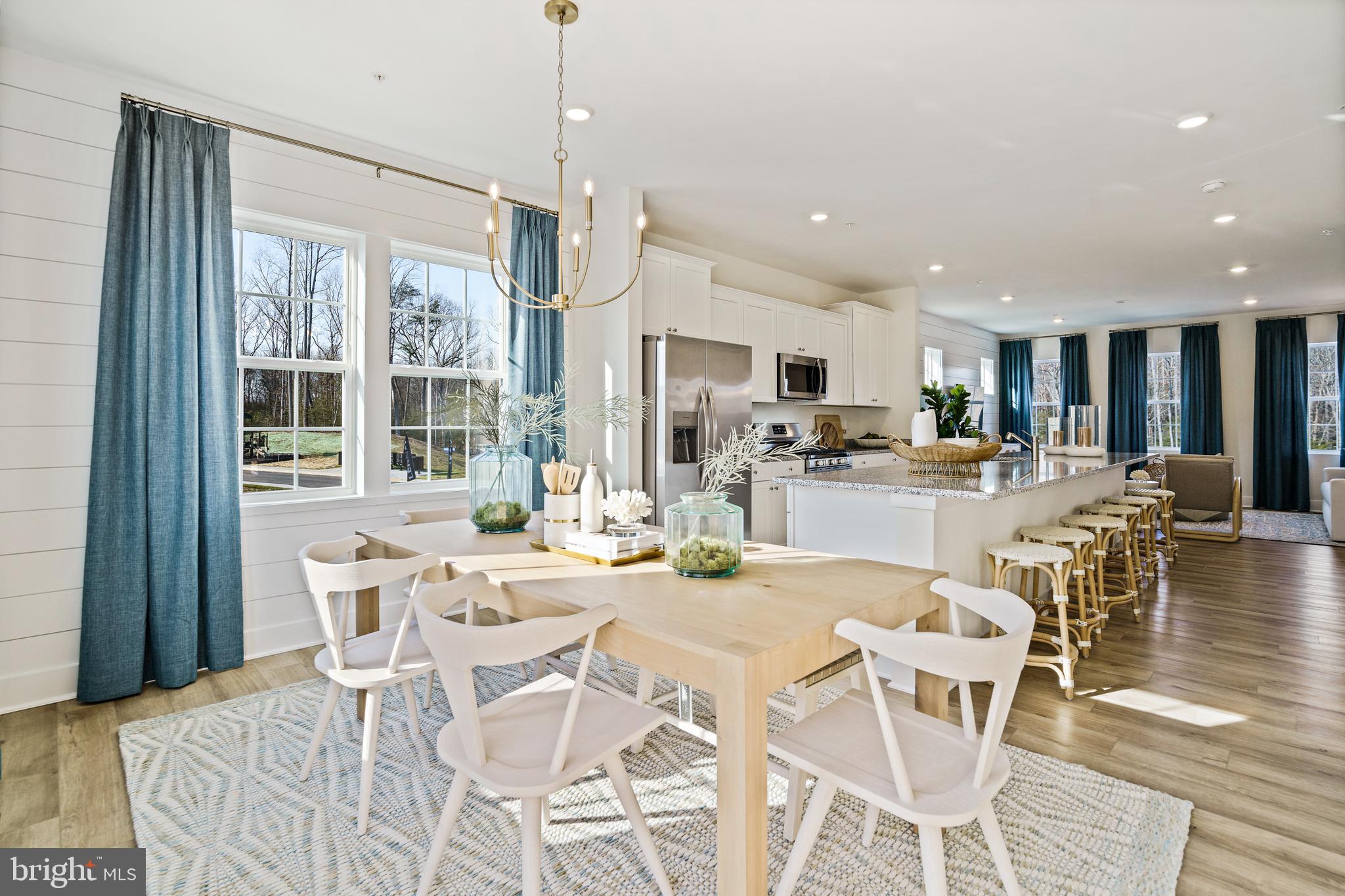 23600 Crosswinds Way California, MD 20619 - Photo 15 of 55 a view of a dining room and livingroom with furniture wooden floor a chandelier