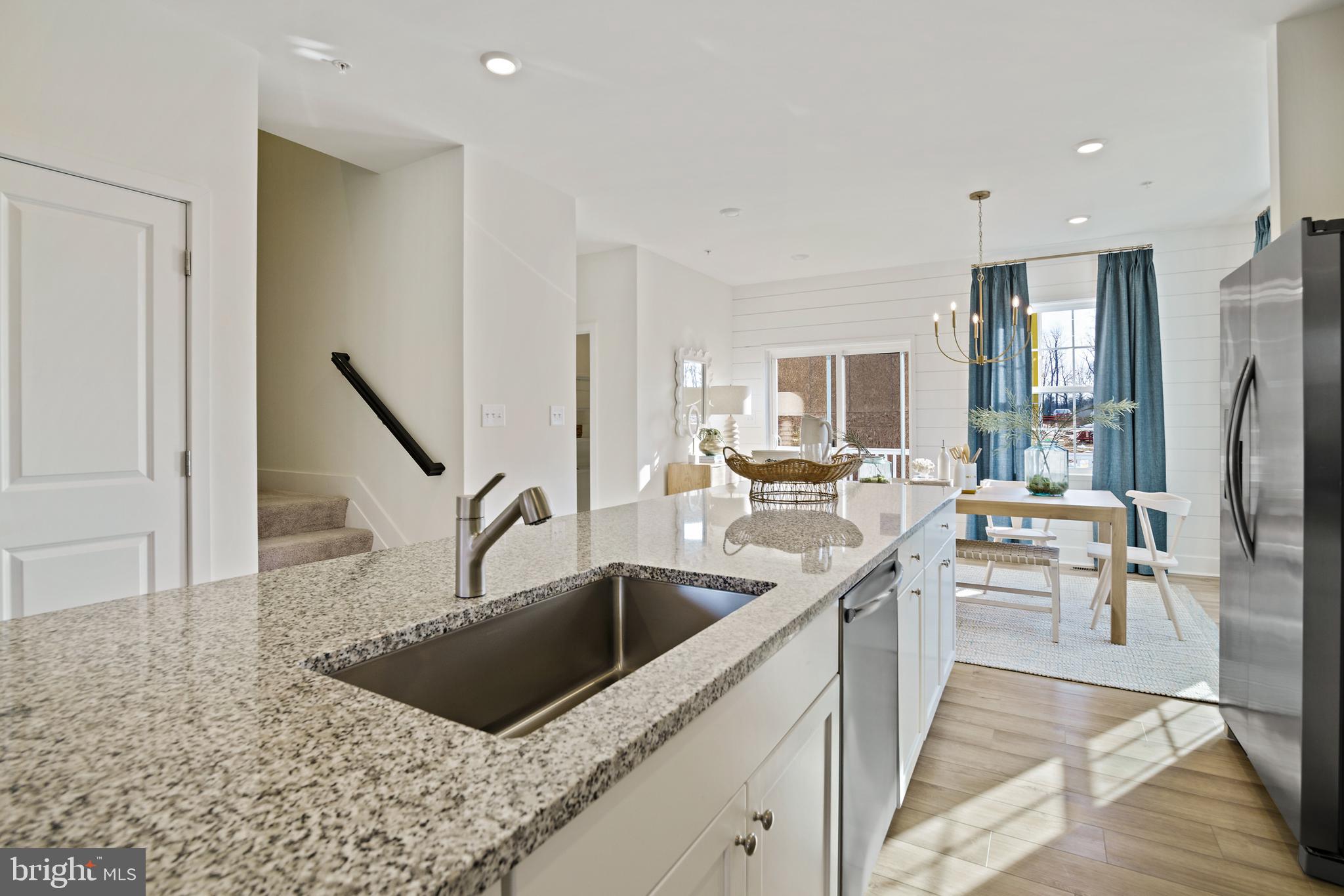 23600 Crosswinds Way California, MD 20619 - Photo 21 of 55 a kitchen with stainless steel appliances kitchen island a sink a counter top space and living room view