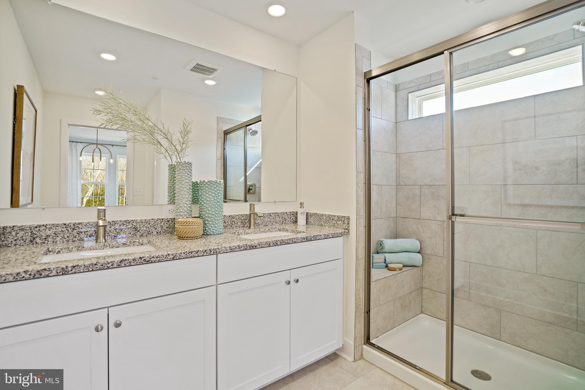 23600 Crosswinds Way California, MD 20619 - Photo 38 of 55 a bathroom with a granite countertop sink a mirror and a shower