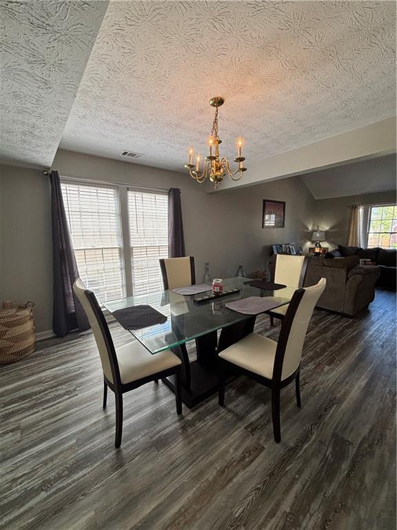 4949 Penscot Way Stone Mountain, GA 30088 - Photo 7 of 40 a dining room with wooden floor a chandelier a wooden table and chairs