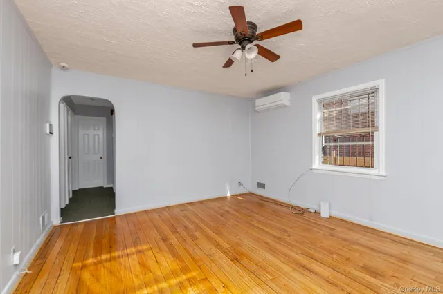 a view of a big room with wooden floor and windows