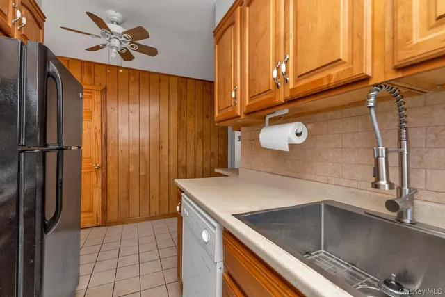 a kitchen with a sink a refrigerator and cabinets