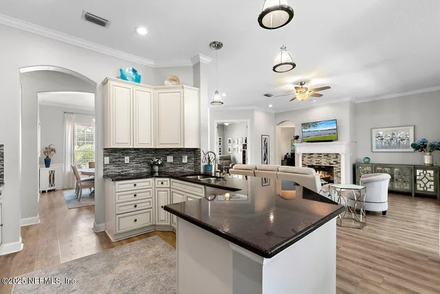 a kitchen with stainless steel appliances granite countertop a sink counter space and living room view