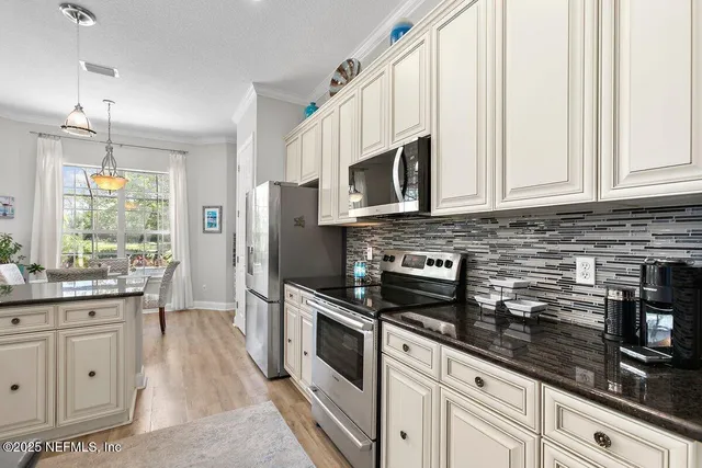 a kitchen with white cabinets and appliances
