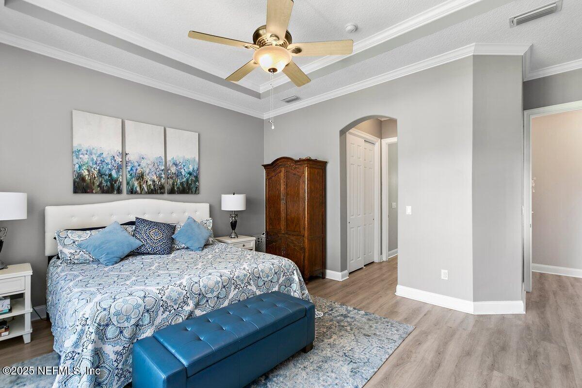 417 Blagdon Court Jacksonville, FL 32225 - Photo 21 of 43 a bedroom with a large bed and a chandelier