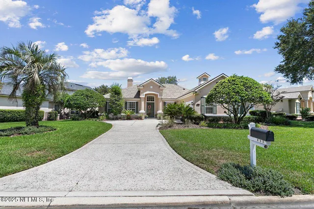 a front view of a house with yard and green space