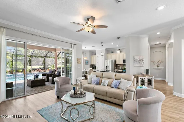 a living room with furniture kitchen view and a large window