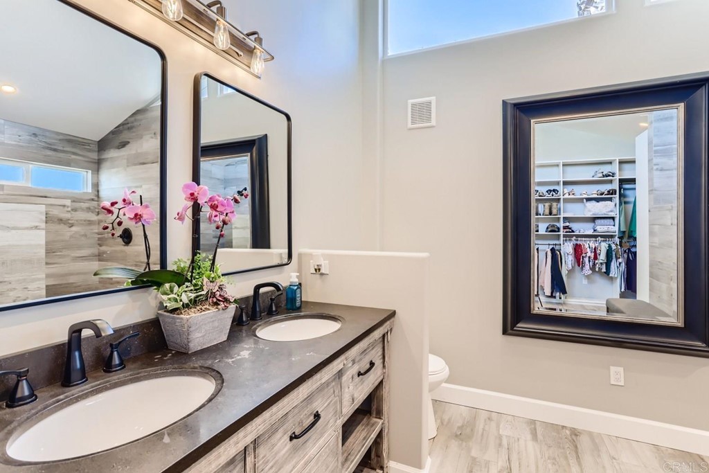 2015 Shadow Grove Way Encinitas, CA 92024 - Photo 15 of 28 a bathroom with a granite countertop sink a mirror and a shower