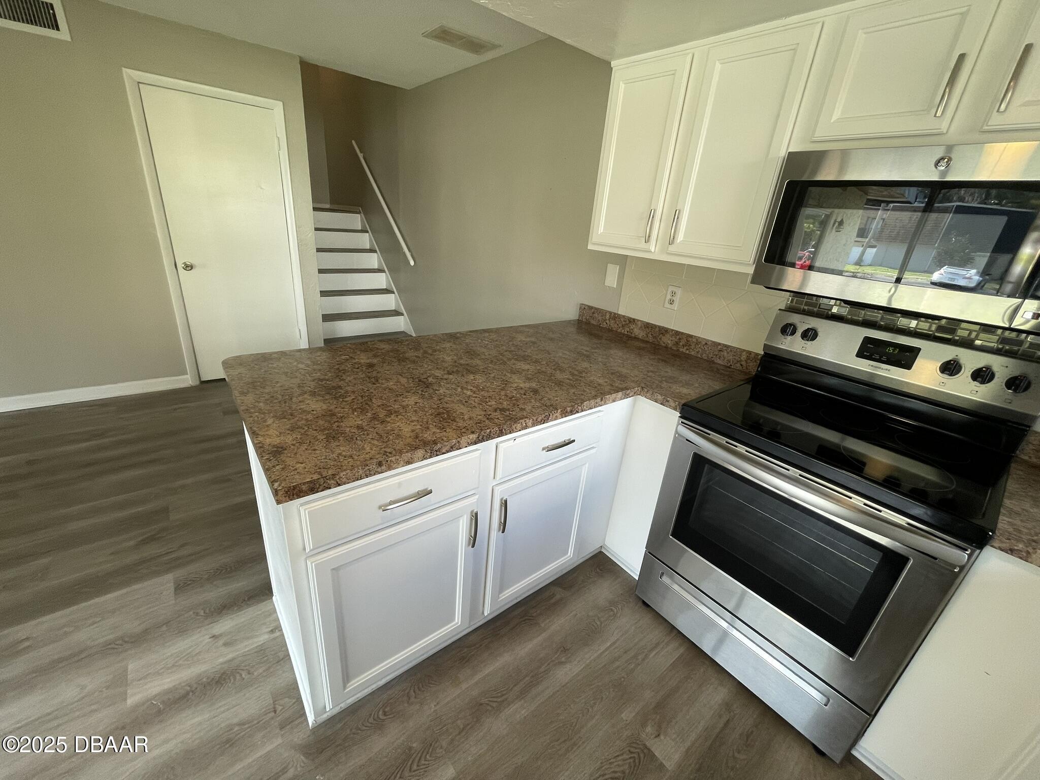 97 Springwood Square Port Orange, FL 32129 - Photo 10 of 23 a kitchen with granite countertop a stove and a microwave