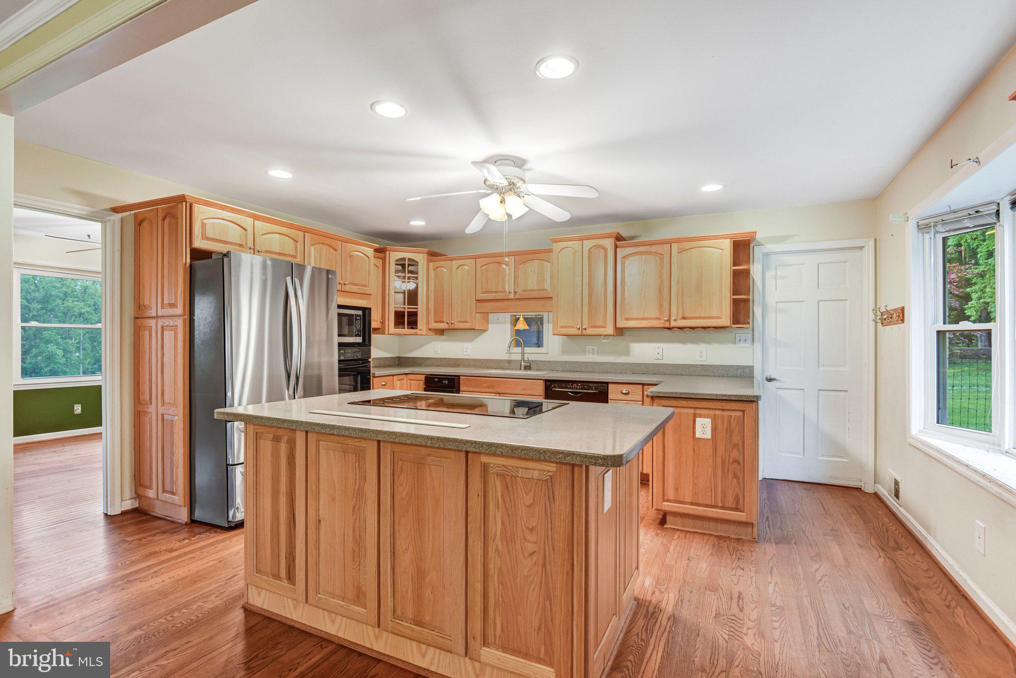 7961 Leeds Manor Road Marshall, VA 20115 - Photo 12 of 40 a kitchen with stainless steel appliances granite countertop a refrigerator a sink dishwasher a stove and white countertops with wooden floor
