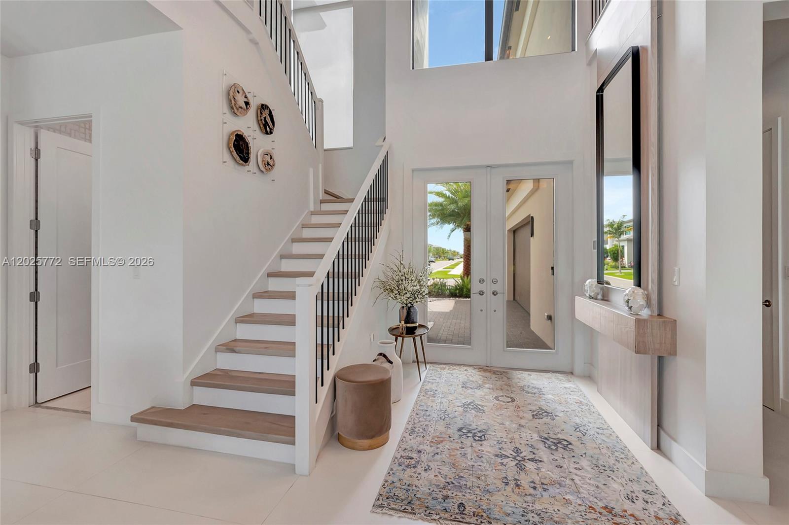 17023 Wandering Wave Avenue Boca Raton, FL 33496 - Photo 10 of 84 a view of an entryway with wooden floor and a livingroom