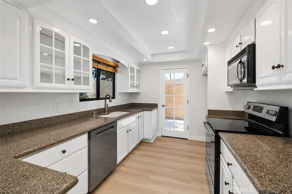 a kitchen with stainless steel appliances granite countertop a sink stove and cabinets